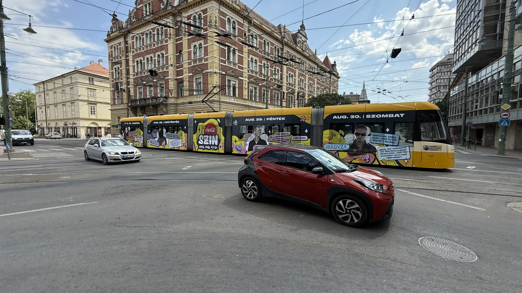 Reklámdekorációval borított villamos városi környezetben